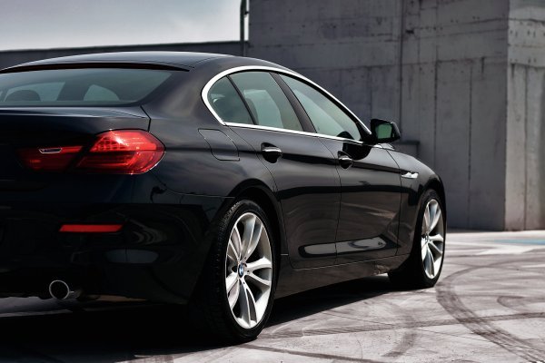 A black car is parked on a concrete surface.