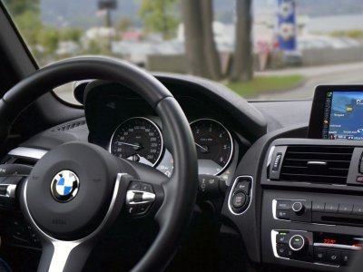Interior of a car featuring a steering wheel, center console, speedometer, gearshift, and various gauges.